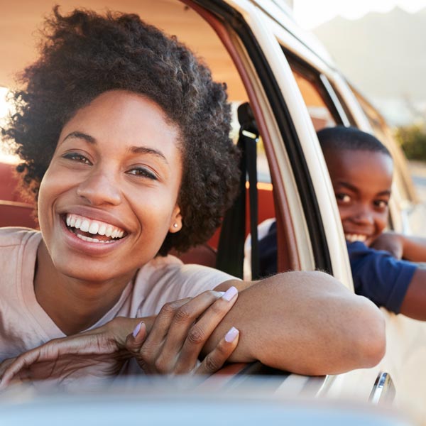 mother and son smiling out of car window